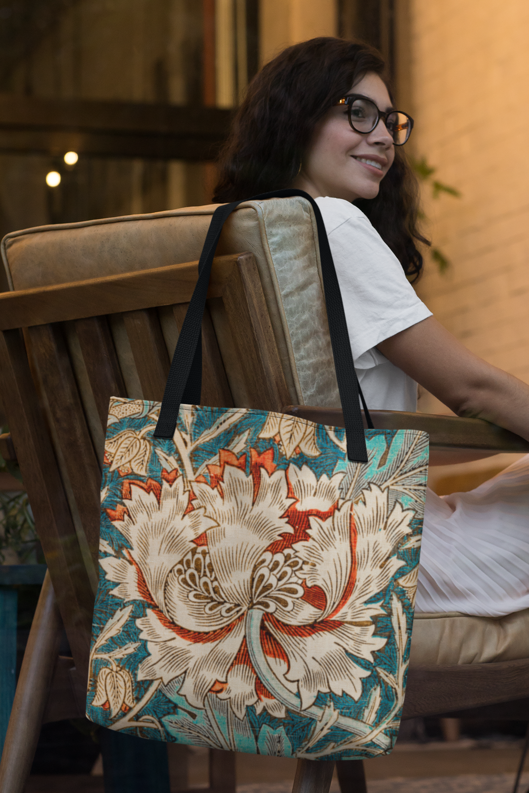 Woman sitting on a chair with a floral tote bag on her lap